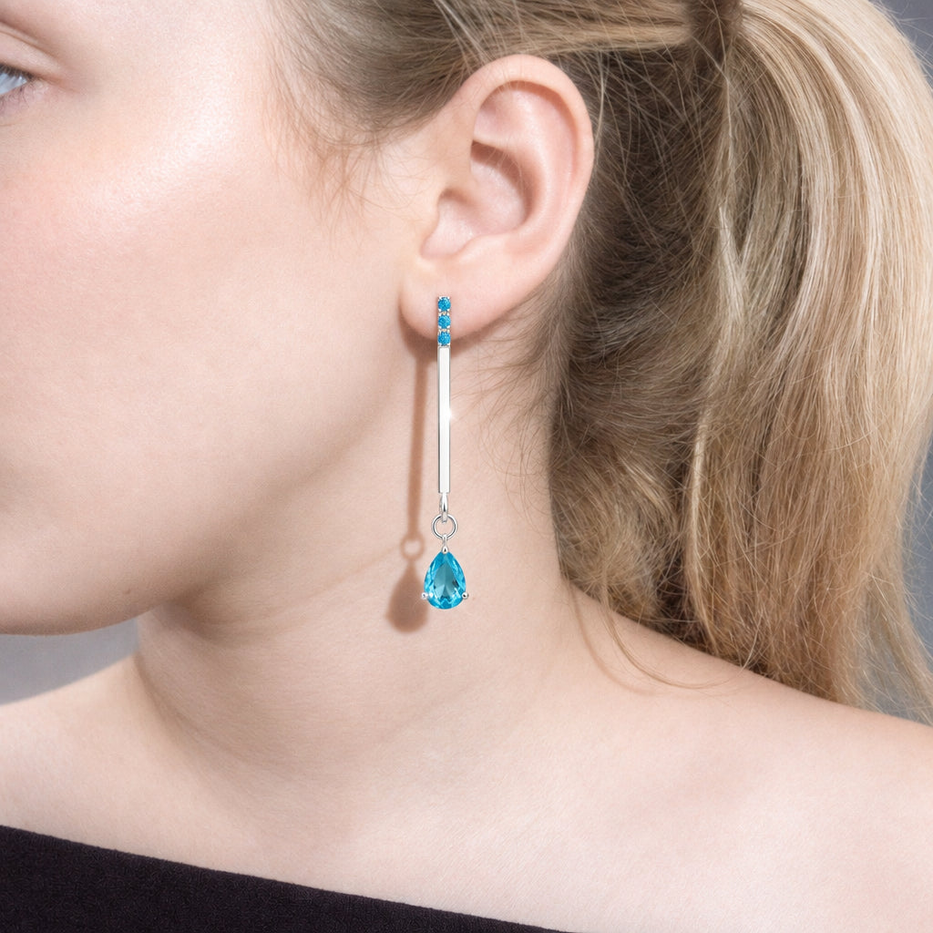 Close-up of blue drop earring on the ear – 925 silver line with three tiny blue zircons