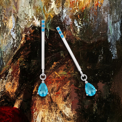 Blue zircon drop earrings on an oil-painting texture