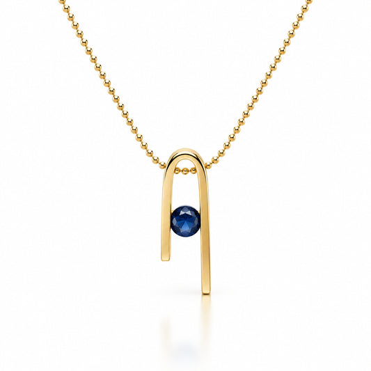 14K gold plated Minimalist n Necklace on a white background: a deep blue zircon at the centre of the n-shaped pendant, with a bead chain running through the form