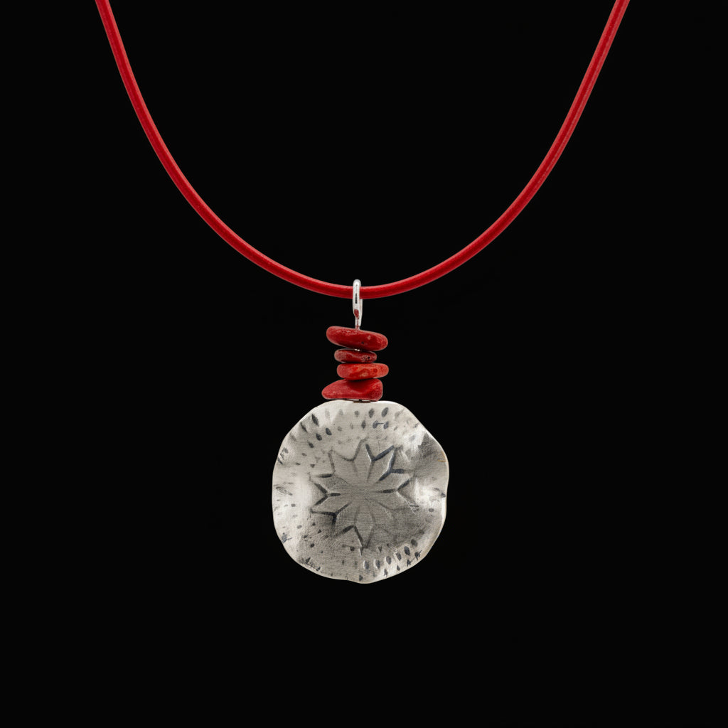 Polaris Necklace on a black background - North Star motif and coral stone detail