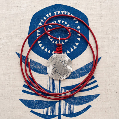 Polaris Necklace flat lay on navy printed fabric - shown with its red rubber cord