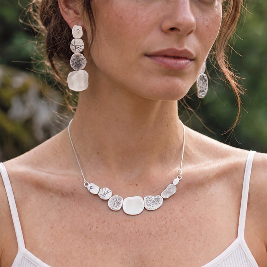 Stone Earrings worn with the matching Stone Necklace by a model in a white strappy top, close at the collarbone