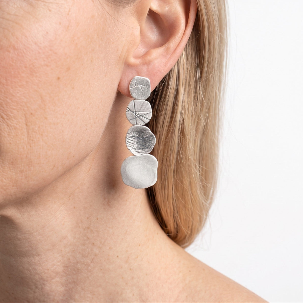 Stone Earring worn on the ear, seen in profile, showing the full length of the oxidized silver drop