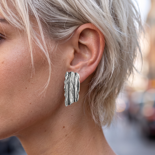 Tree Bark Earrings - worn on the ear of a model with short silver blonde hair, side view